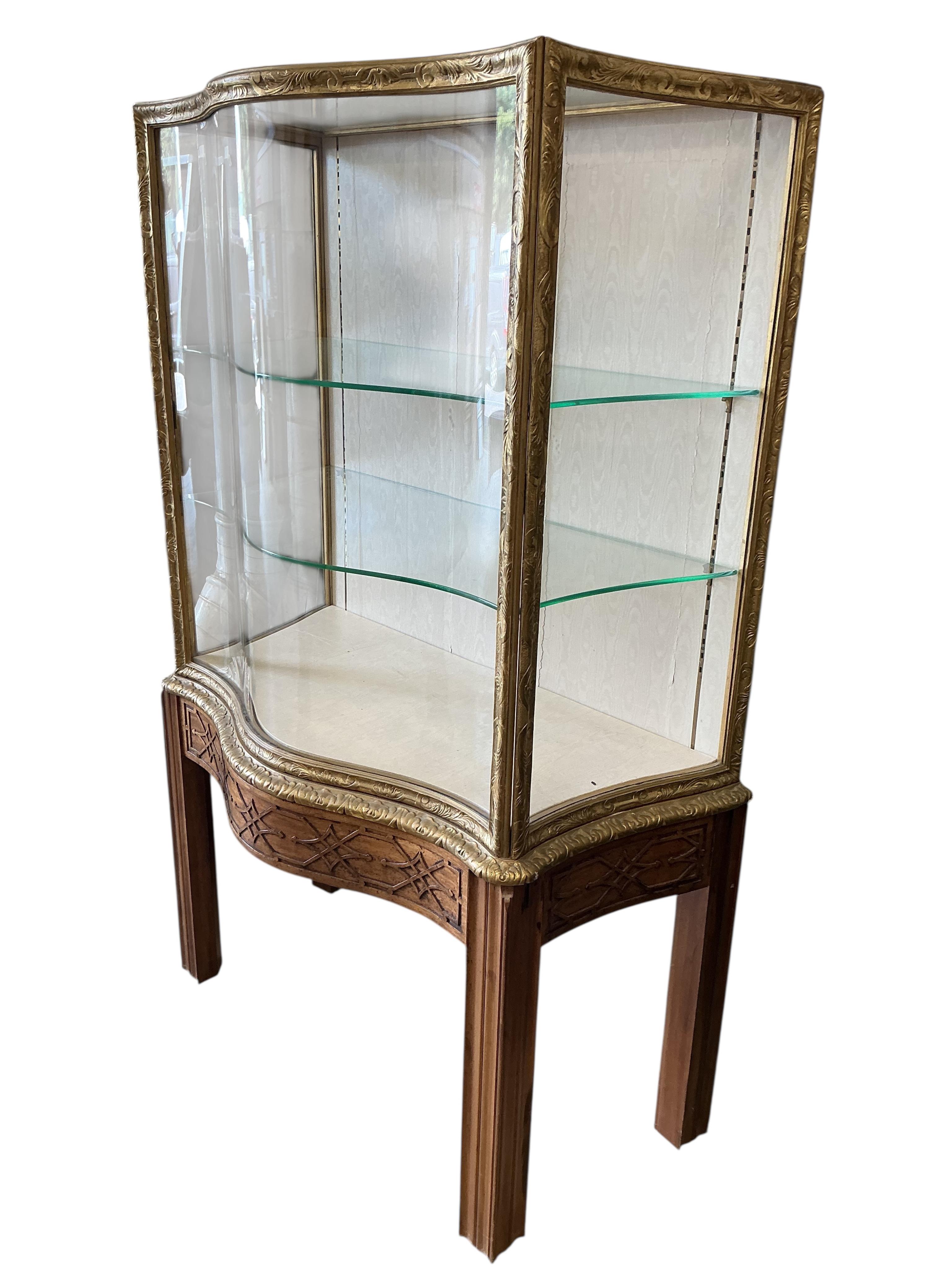 A George III style mahogany and giltwood serpentine display cabinet on blind fret stand, width 106cm, depth 60cm, height 181cm